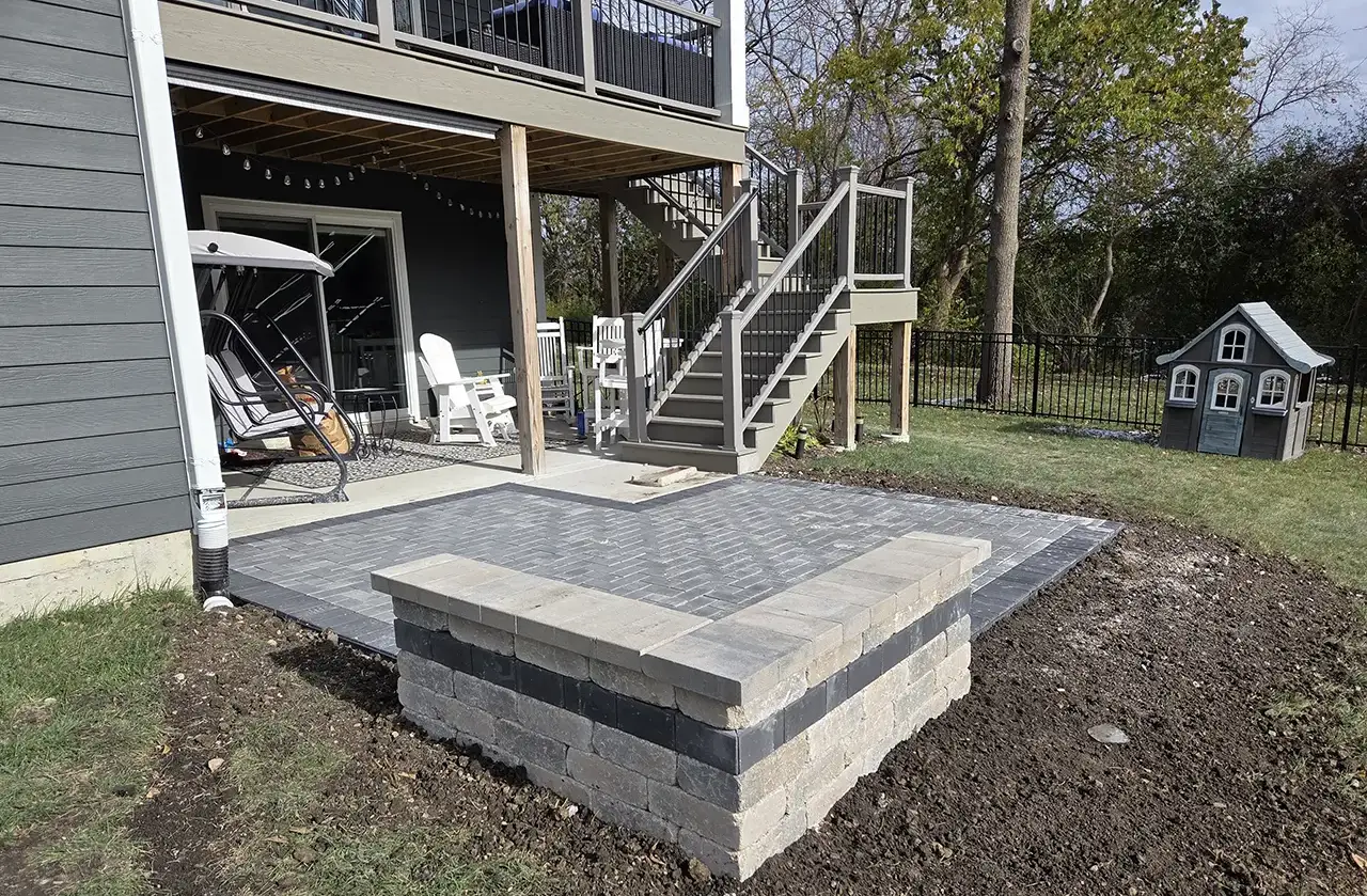 Brick paver patio with raised seating wall installed behind a residential home in Palatine, IL